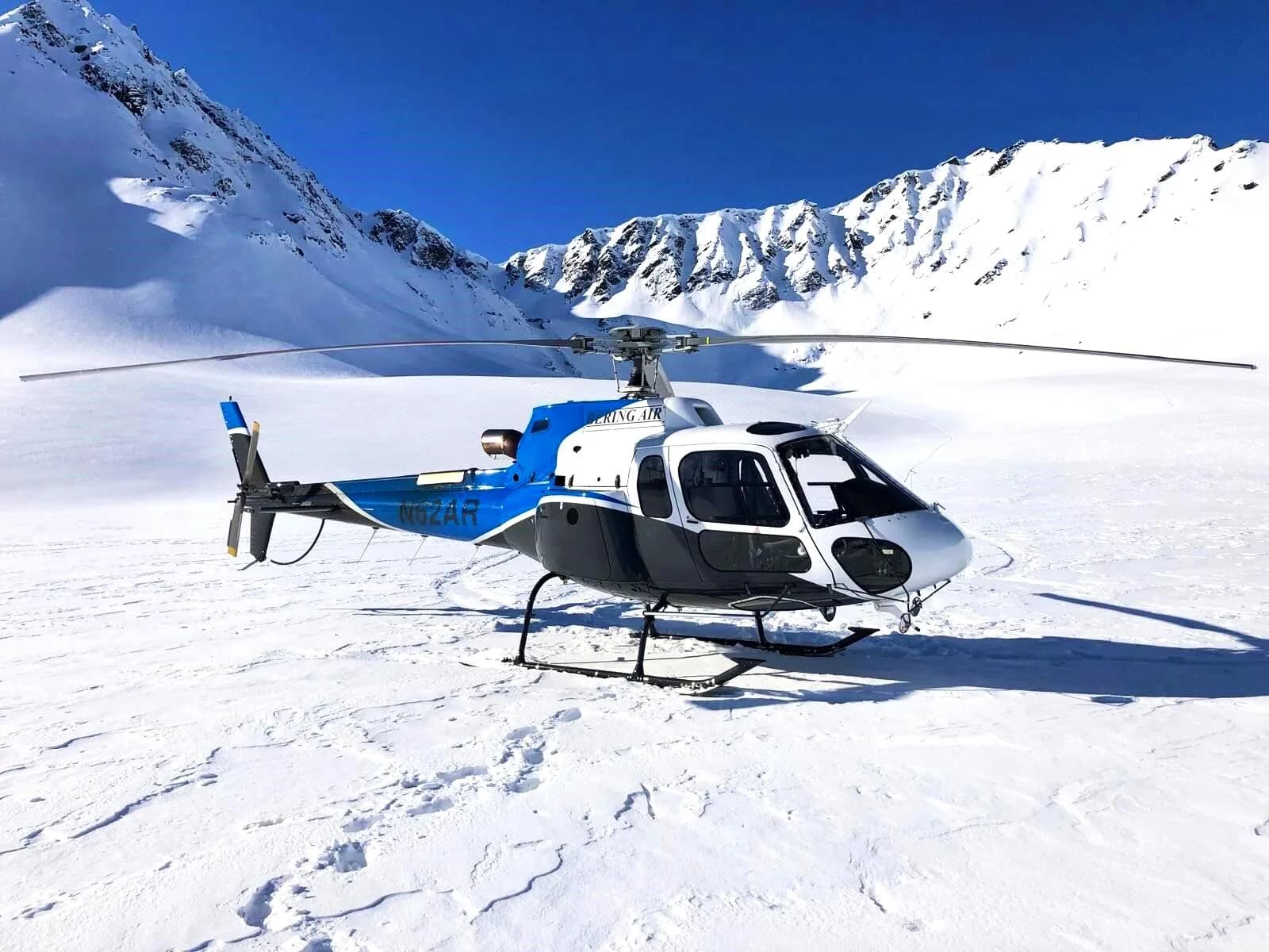 N62AR helicopter on a snowy mountain landscape.