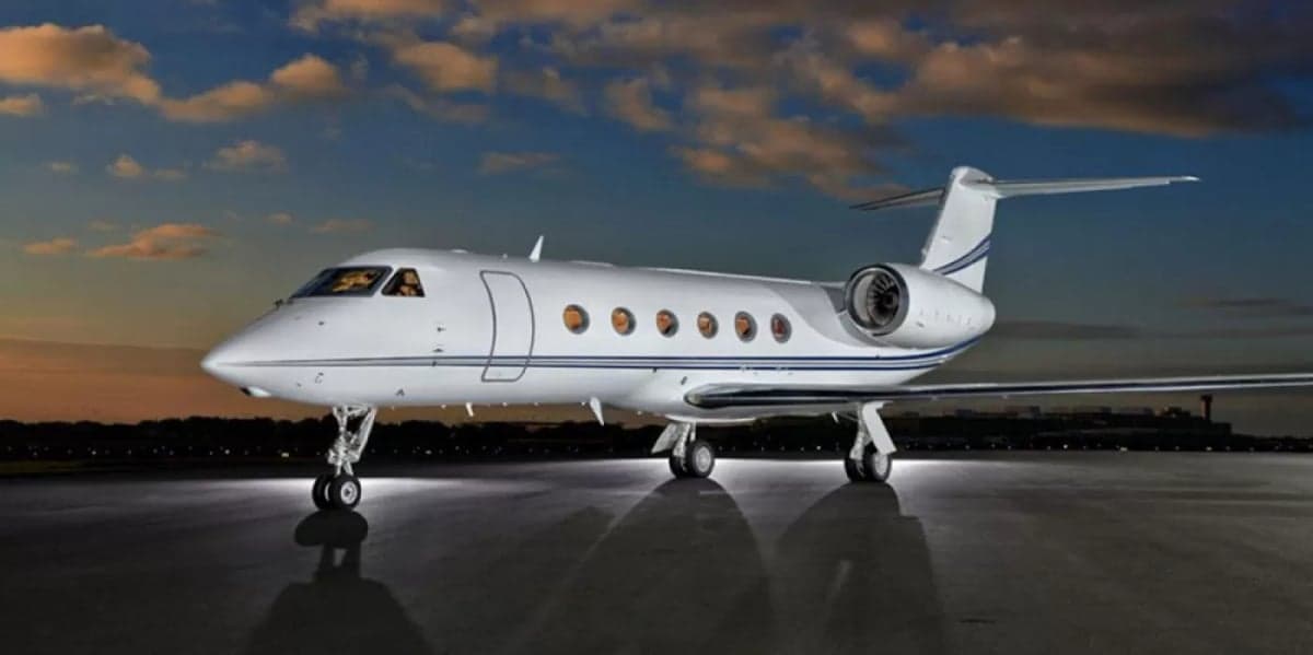 Gulfstream G550 business jet parked on the tarmac at sunset.