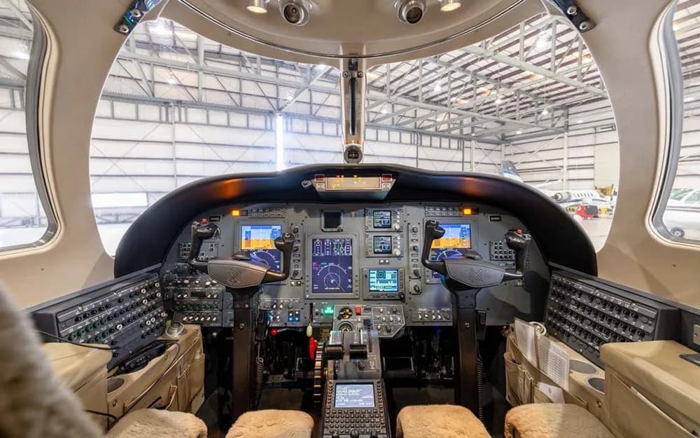 The cockpit of a Cessna Citation CJ3 with multiple display screens and controls, viewed from the pilot's seat.