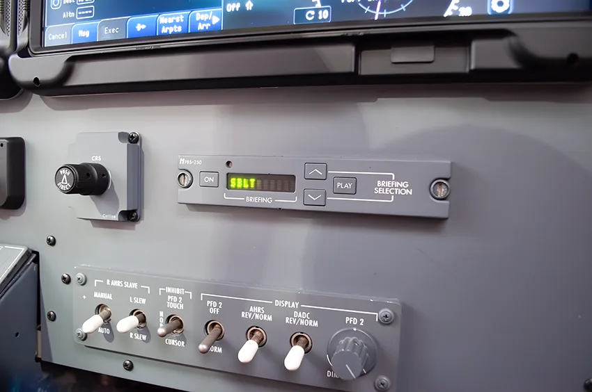 A close-up view of a control panel in the cockpit, showing buttons and a digital display.