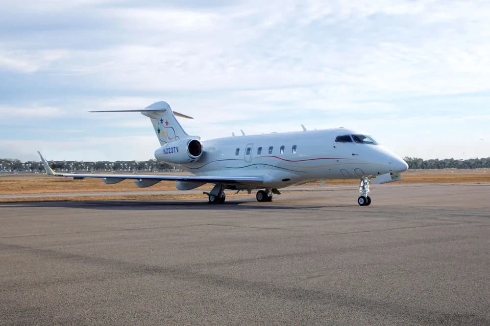 Front view of a white Bombardier Challenger with the airstair door open.