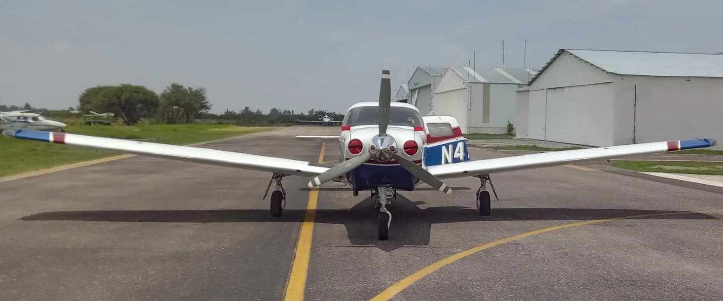 Front view of a Piper Saratoga II TC aircraft with white and blue paint scheme on a tarmac.