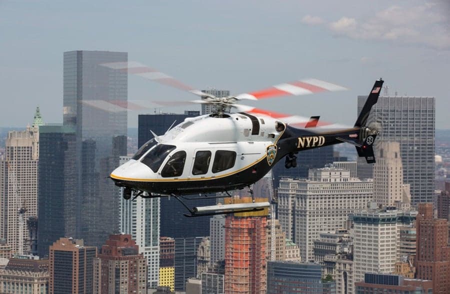 An NYPD helicopter flies over the New York City skyline.