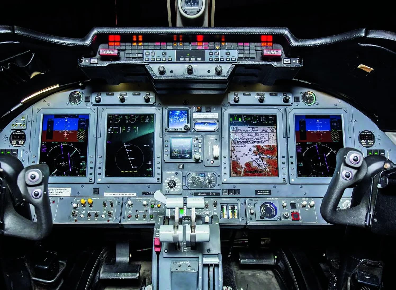 The modern glass cockpit of a Learjet 75, showing multiple display screens and controls.