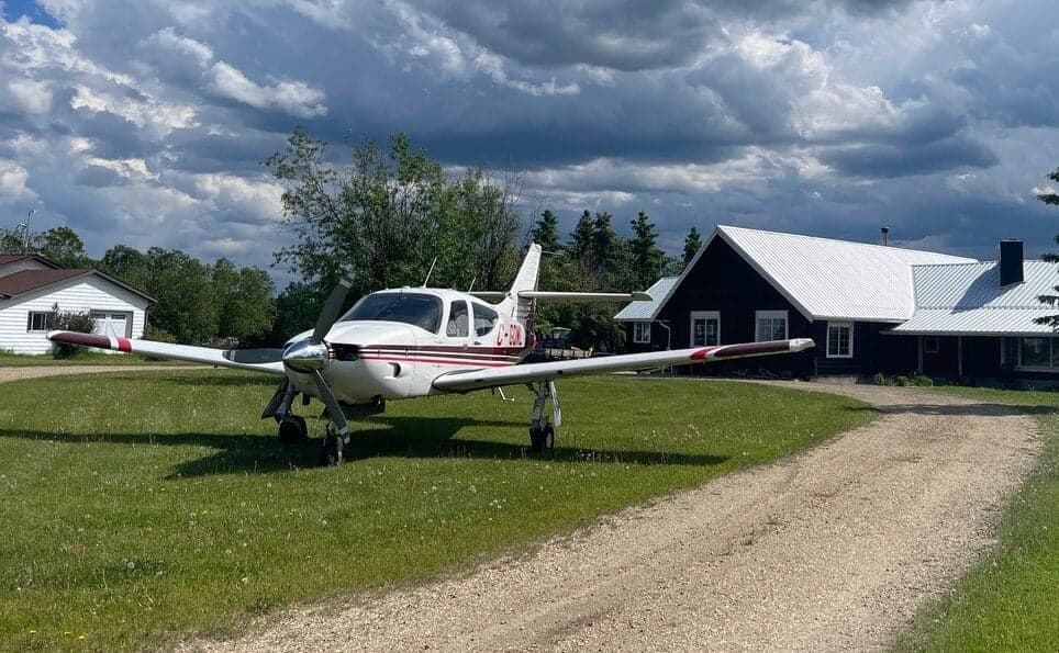 Piper PA-28R-201T Turbo Arrow III parked on a grassy area in front of a house.