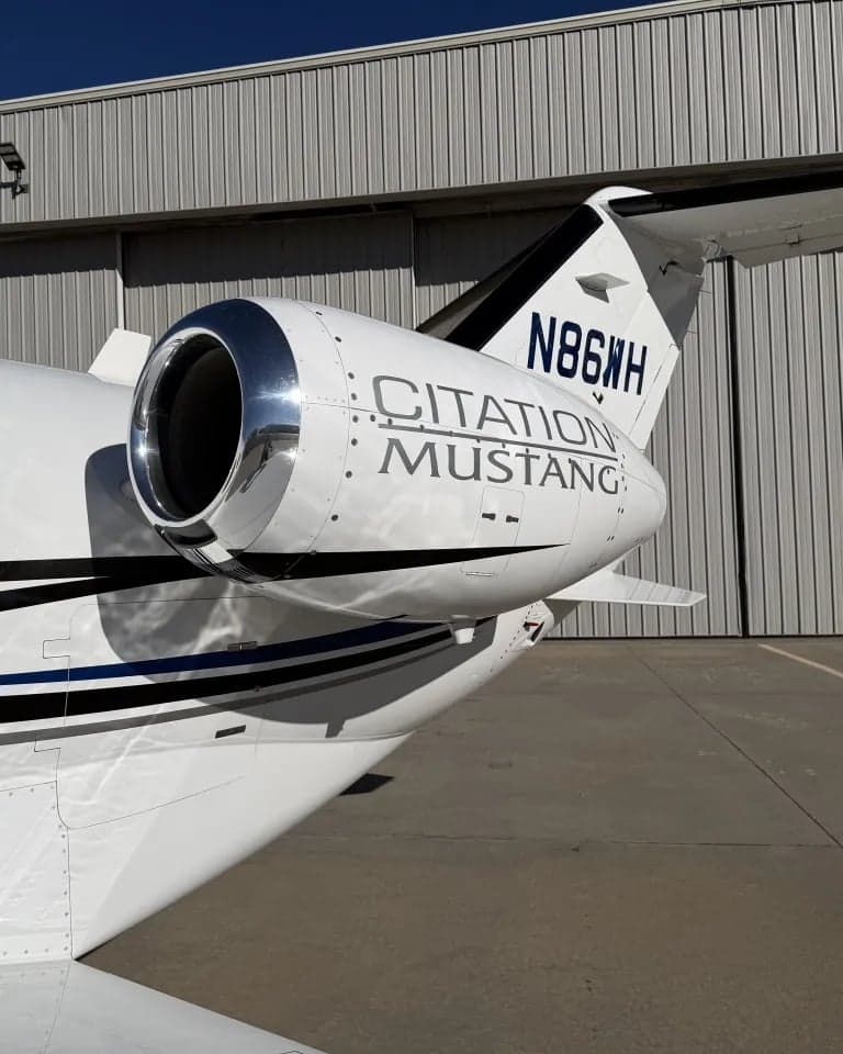 Close-up of the tail section of a Citation Mustang, showing the engine and tail number.