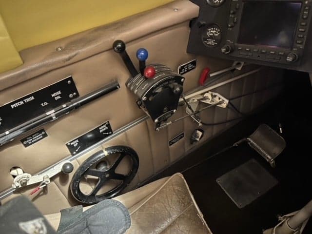 Interior view of the biplane's cockpit showing the rudder pedals and control stick.