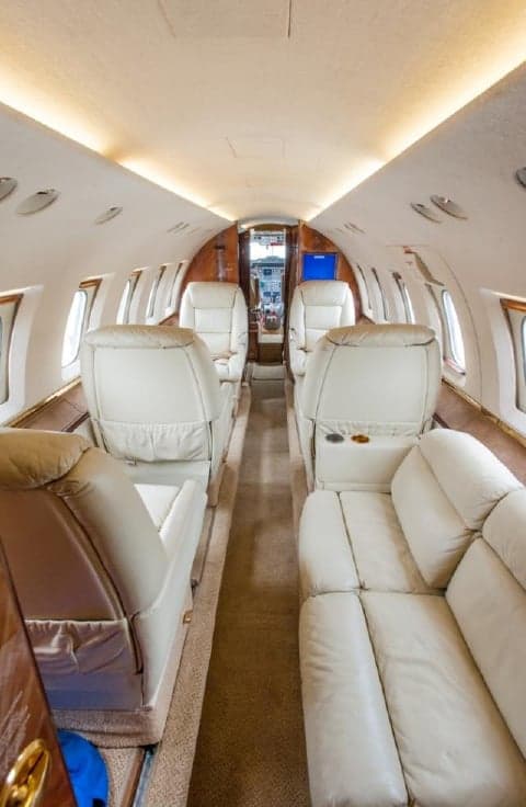 The interior of the aircraft features cream-colored leather seats.