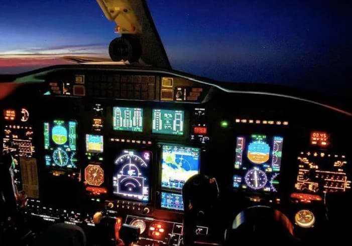 Illuminated cockpit instrument panel at night.