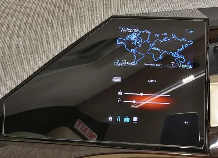 A close-up of an aircraft cabin control panel displaying a world map, time, and light settings.