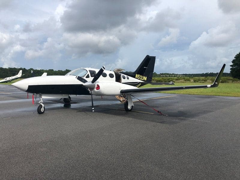 The N513JN aircraft is parked on the tarmac with a black and white paint scheme.