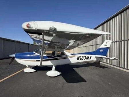 A Cessna 172 Skyhawk with registration N183MK parked outside a hangar.