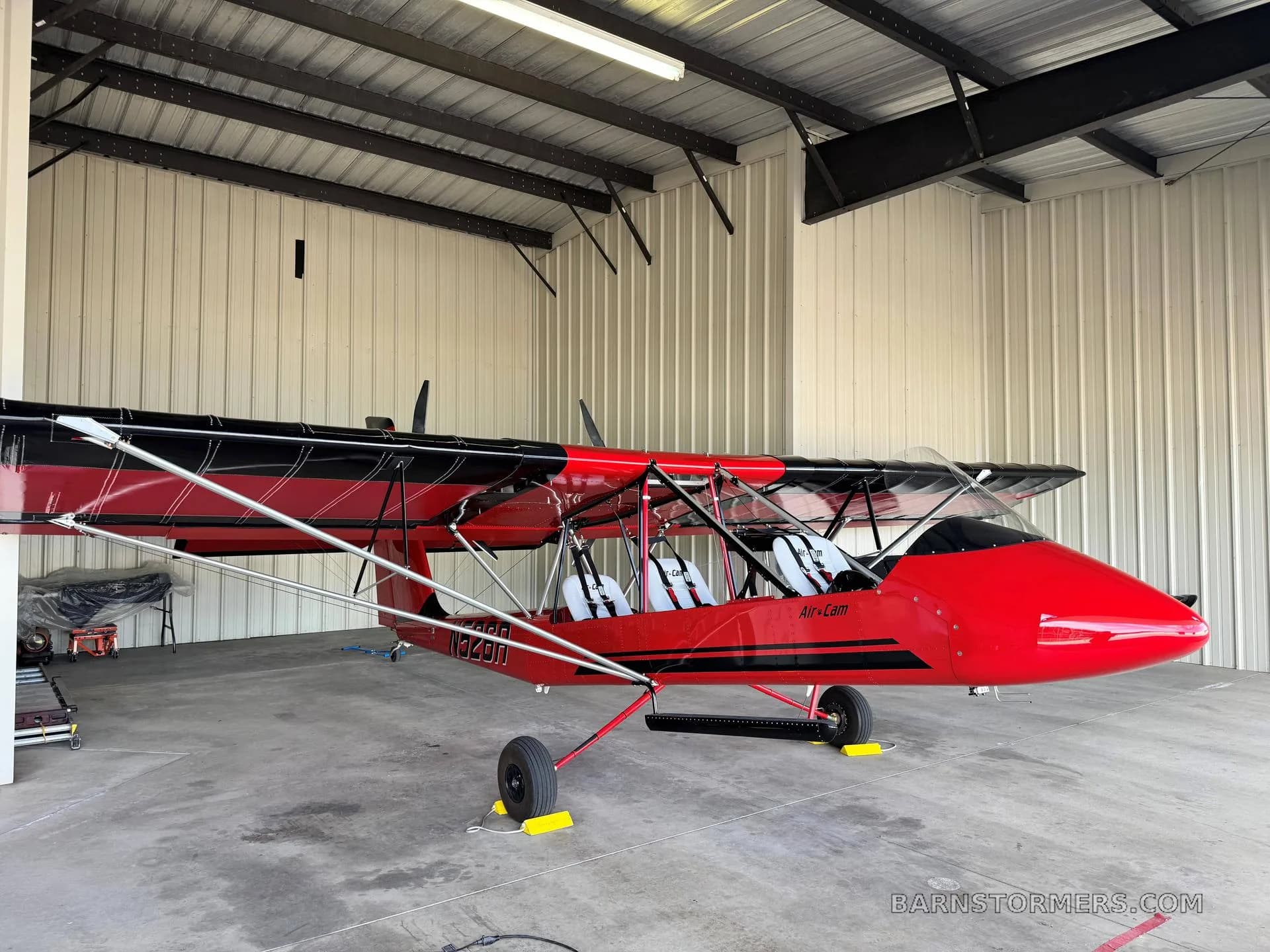 A red and black Air-Cam aircraft with registration N1349U is parked inside a hangar.