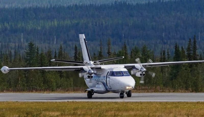 Front view of a white and blue de Havilland Canada DHC-6 Twin Otter on a runway.