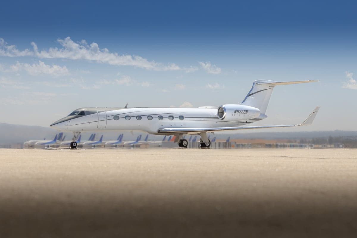 Side view of a white Gulfstream G550 on the tarmac.