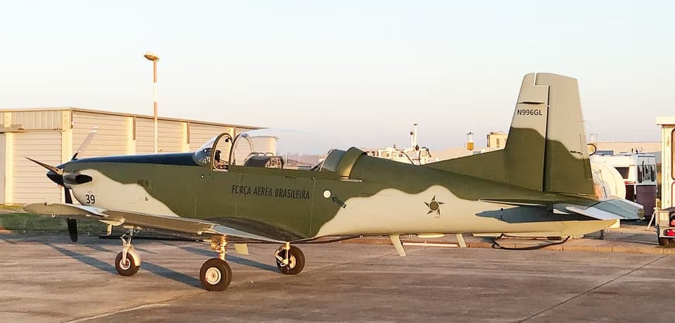 A Tucano aircraft with registration N996GL parked on the tarmac.