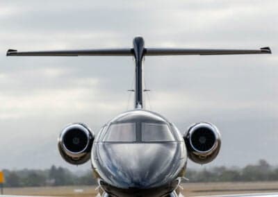 Close-up front view of a black Pilatus PC-24 jet on the tarmac.