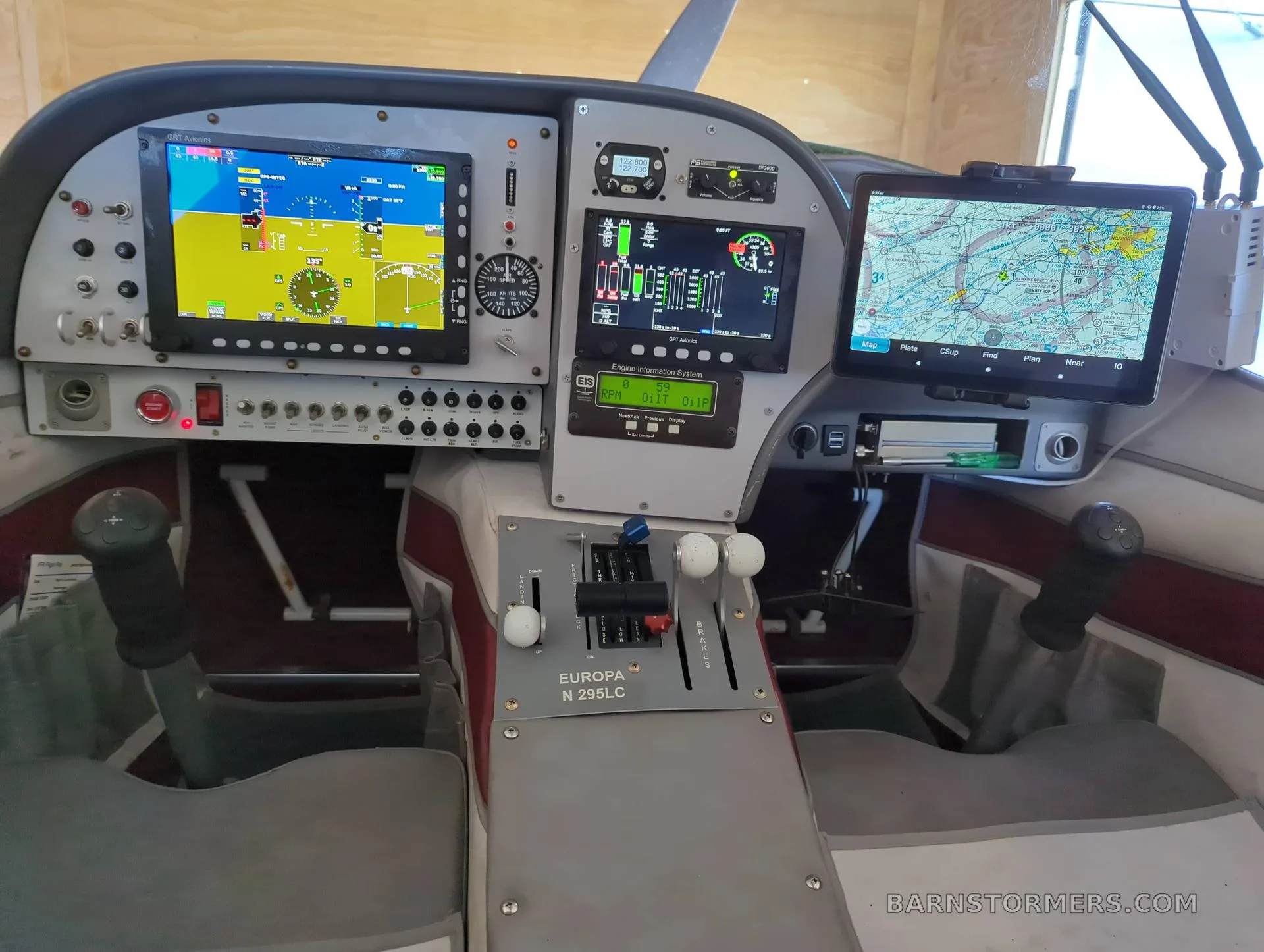 The cockpit of a Europa aircraft with multiple digital displays and flight controls.