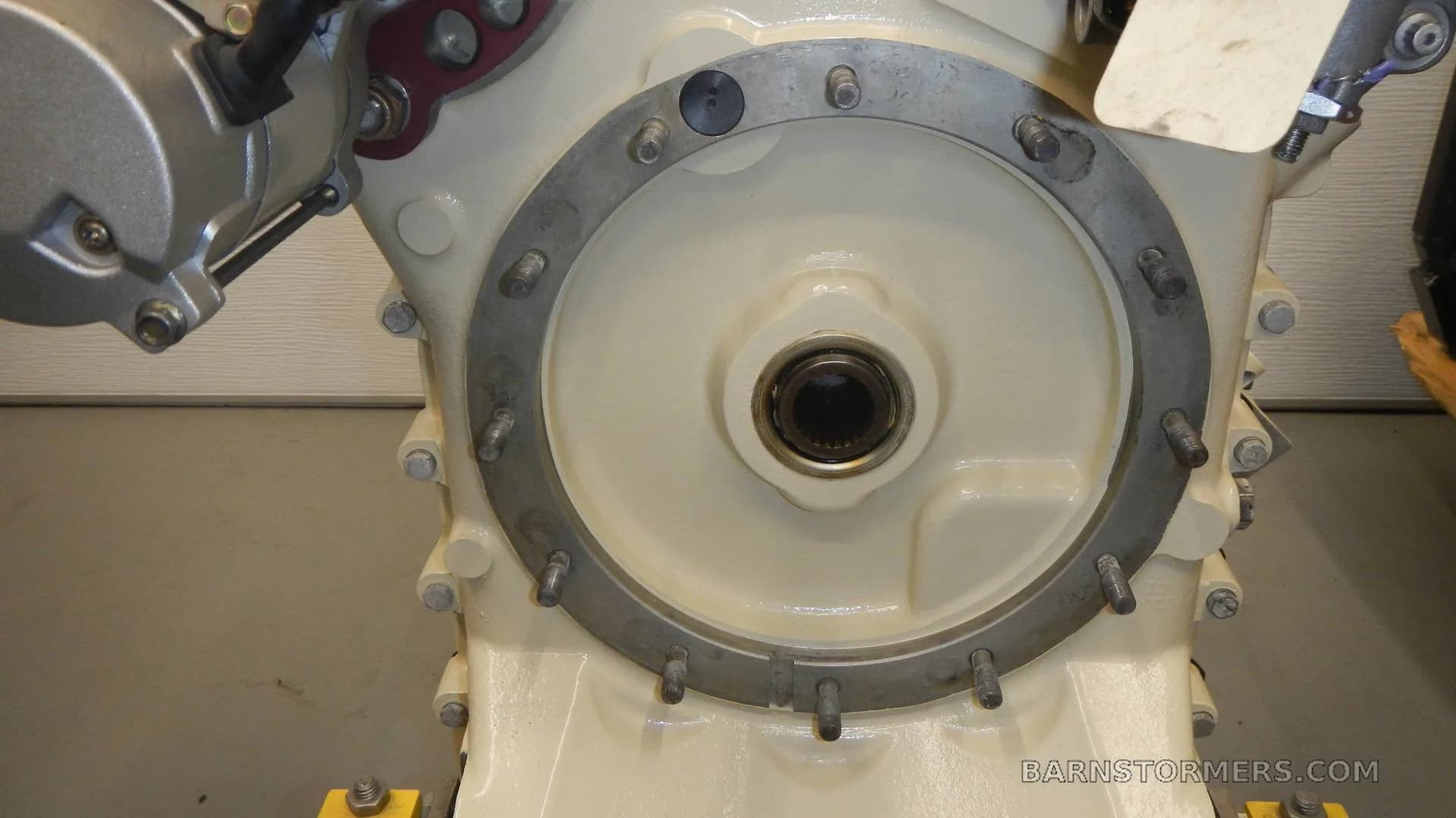 A close-up view of a circular bolted plate and a central shaft on an aircraft engine.