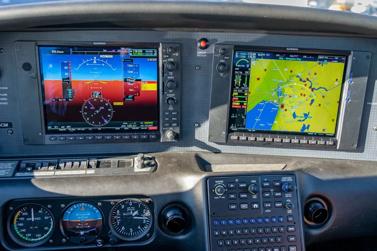 A detailed view of the aircraft's cockpit instrument panel, featuring two Garmin display screens.