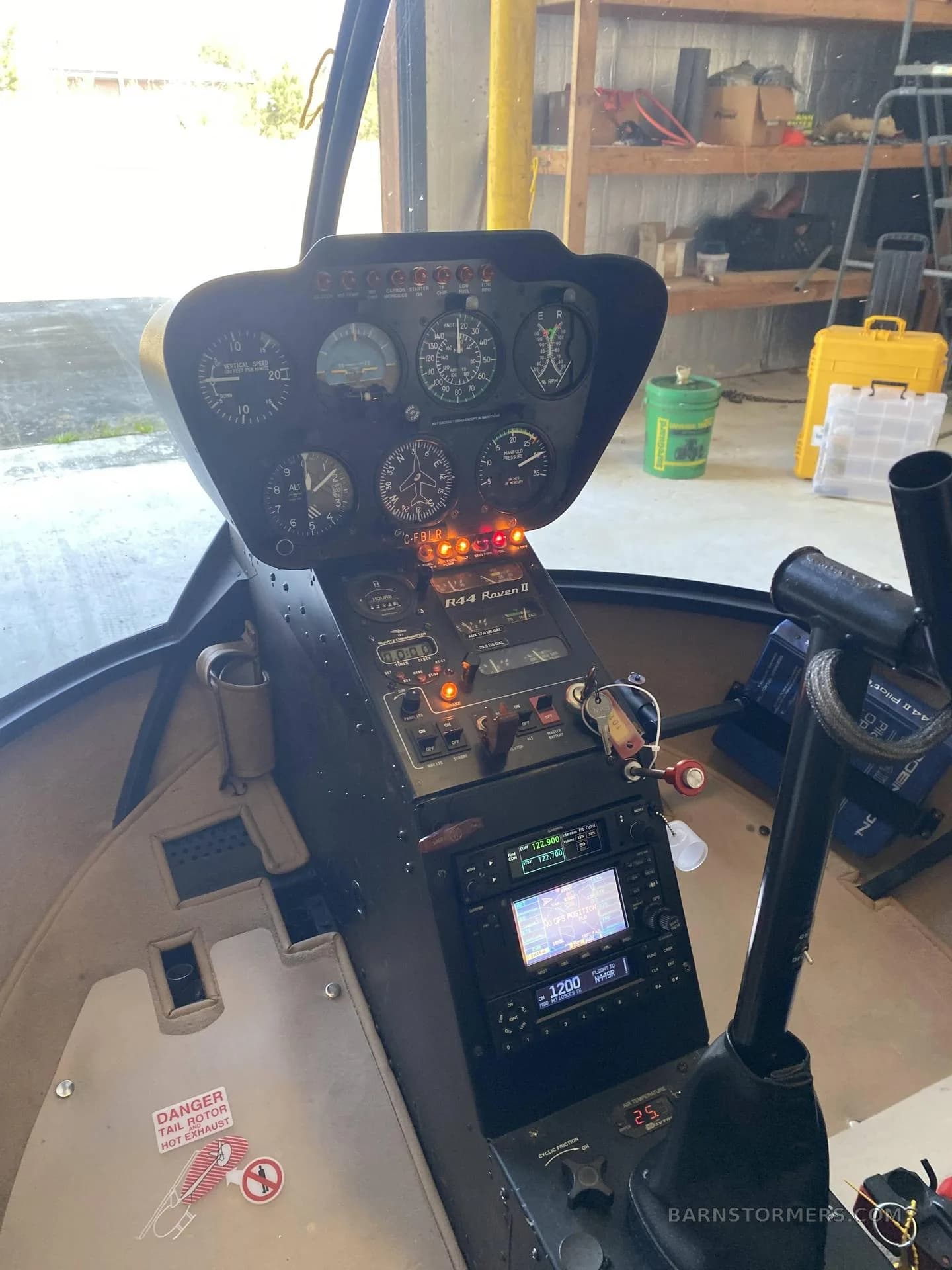 The cockpit of a Robinson R44 Raven II helicopter, showing the instrument panel and controls.