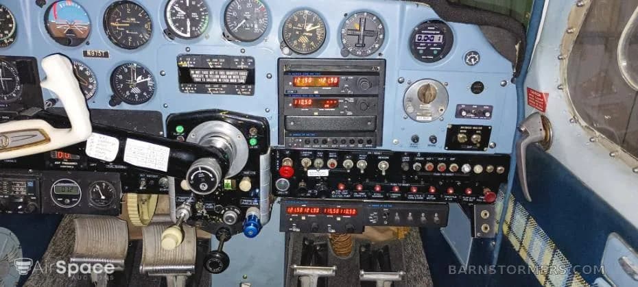 A detailed view of a light aircraft's cockpit, featuring the instrument panel, yoke, and various switches.