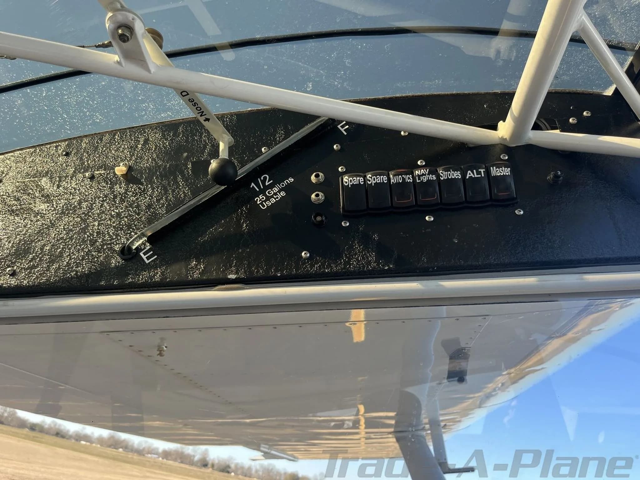 Close-up view of overhead switches and a fuel selector lever in the cockpit of the aircraft.