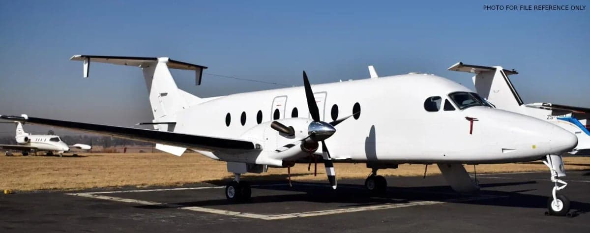 Side view of a white turboprop aircraft on the tarmac.
