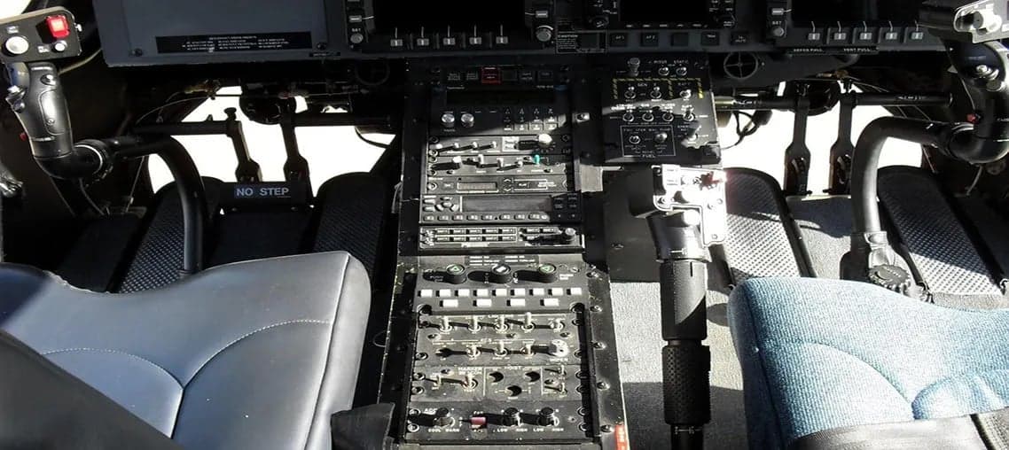 View of the helicopter's cockpit, showing the instrument panel and seats.