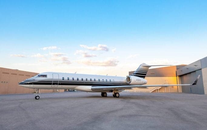 A Bombardier Global Express with a unique black and white paint scheme parked on the tarmac.