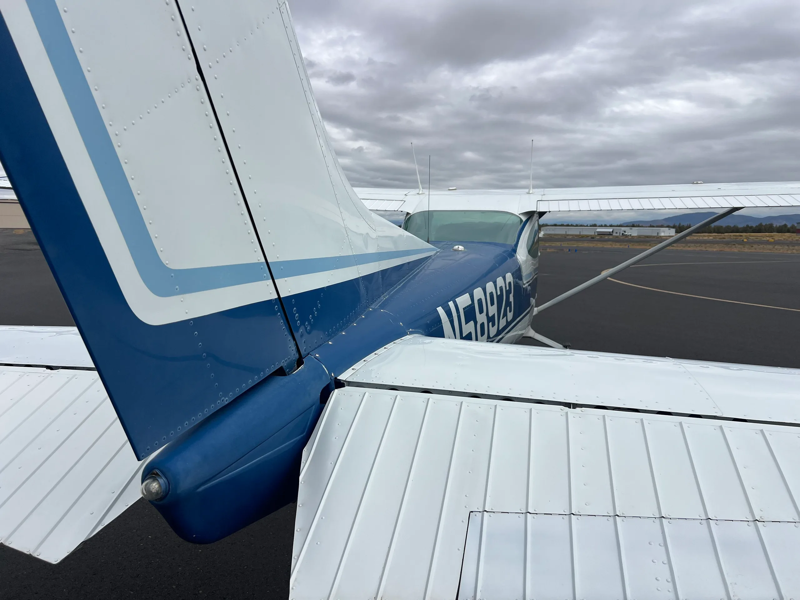 A close-up view of the blue and white tail and rear fuselage of the Cessna 172 aircraft, N58923.