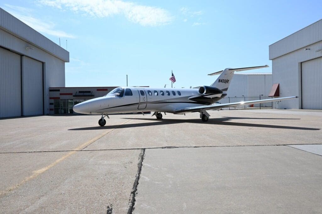 N400RK Cessna Citation CJ3+ parked between two hangars.