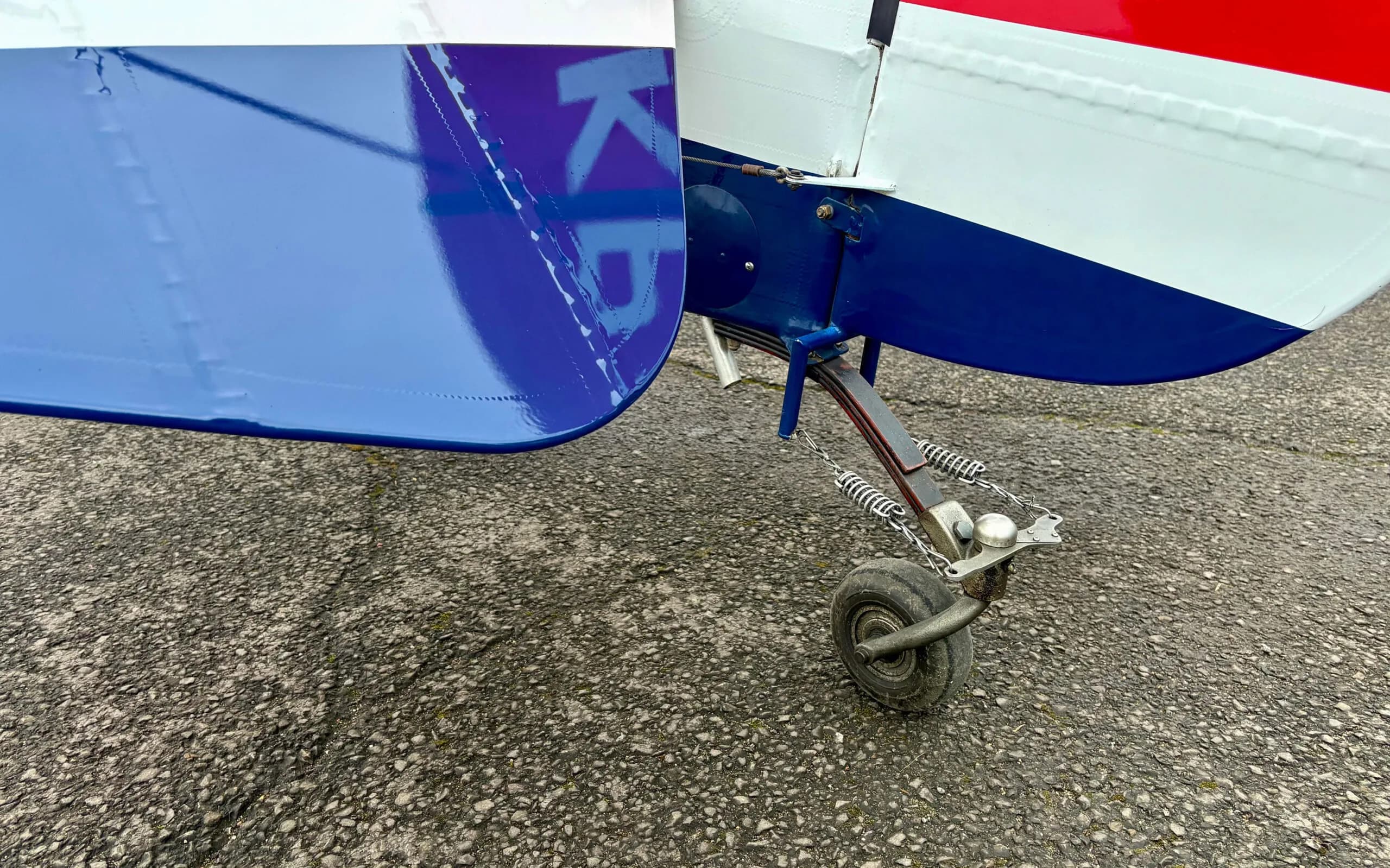 A close-up view of the tail wheel assembly of the Pitts S1T biplane.