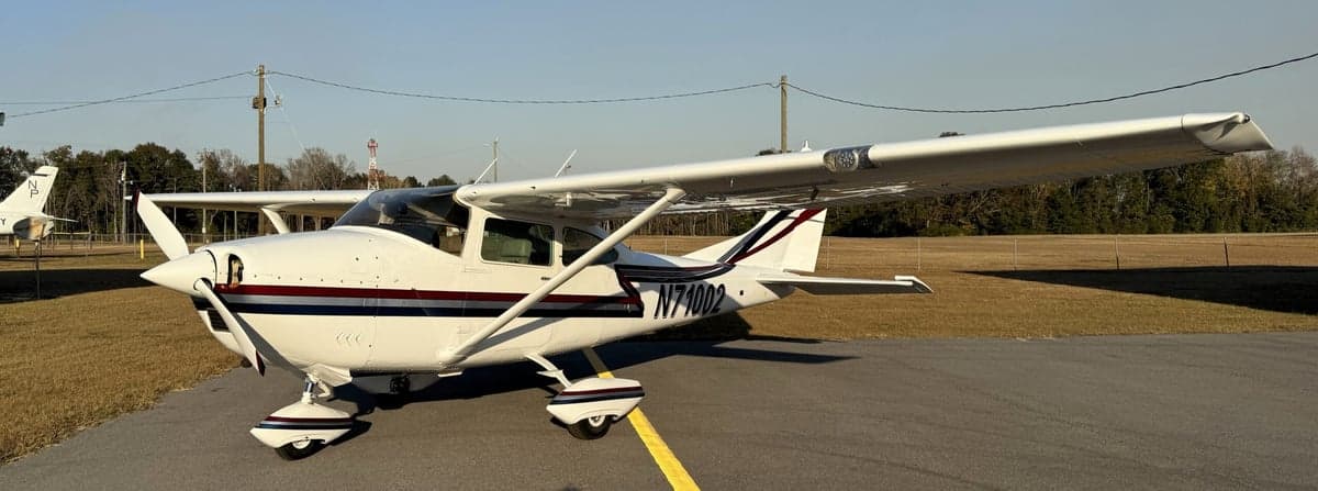 A Cessna 210 Centurion, registration N71002, is parked on the tarmac.