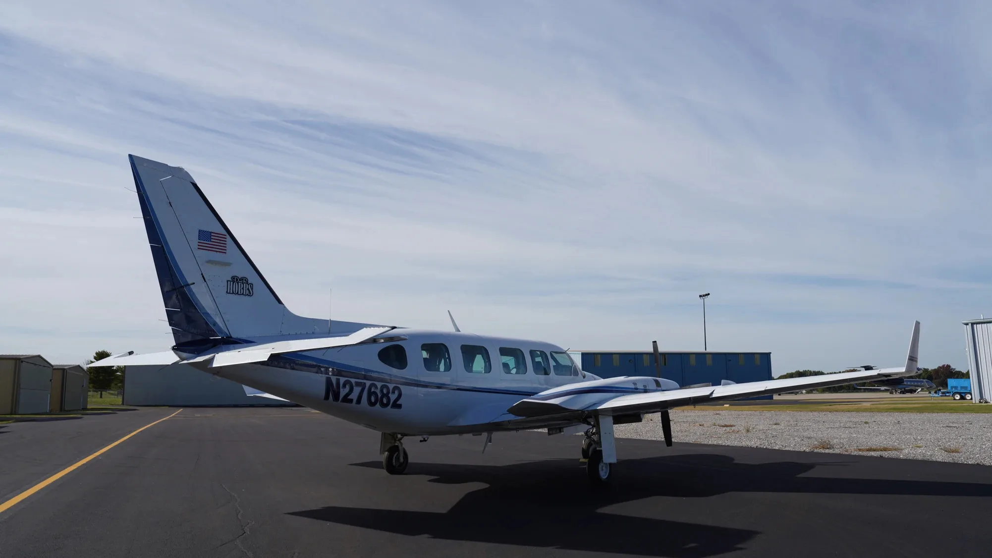Side view of the white and blue twin-engine aircraft with the tail number N27682.