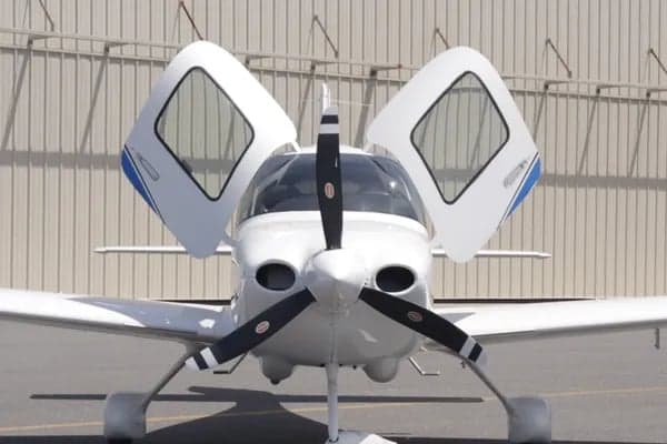 Front view of a Cirrus SR22 aircraft with its doors open.