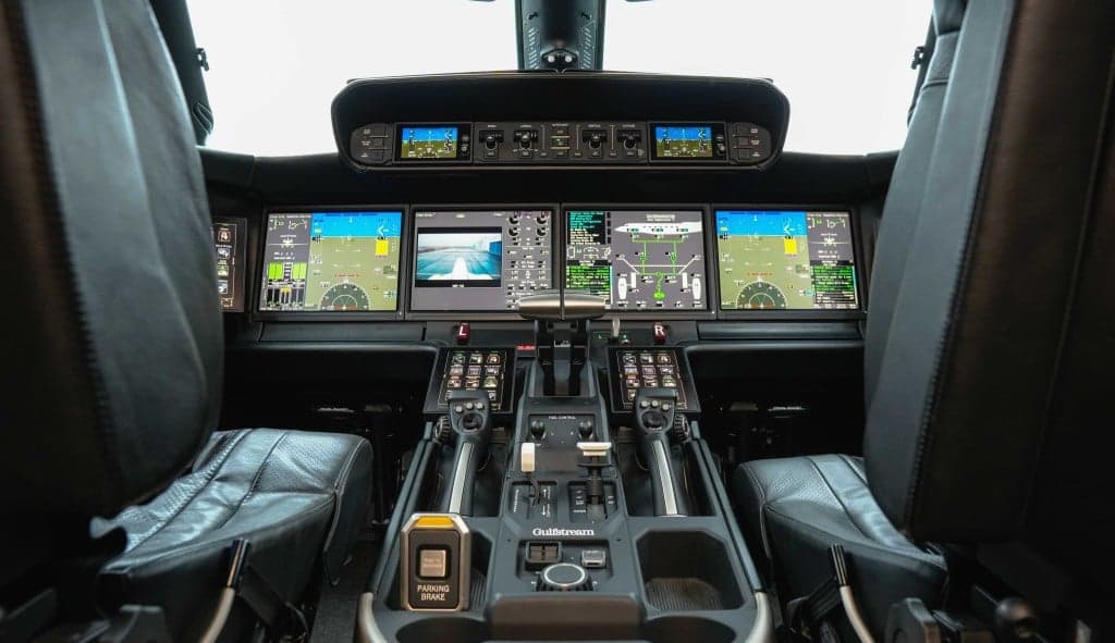 The aircraft's interior features a sofa and leather chairs.