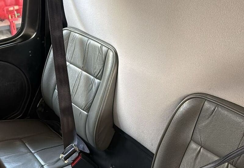 Close-up of the gray leather seats in the cabin of a Robinson R44 helicopter.