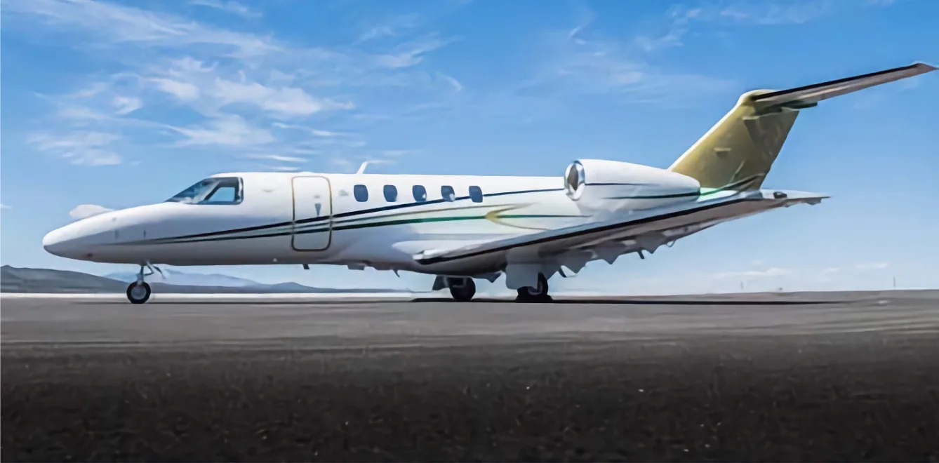 A white and gold jet aircraft on the tarmac.