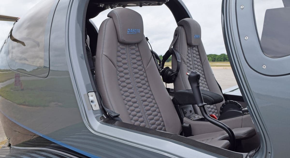The gray leather interior seats of a Diamond DA50 RG aircraft, featuring a quilted pattern and "DA50 RG" embroidered on the headrests.