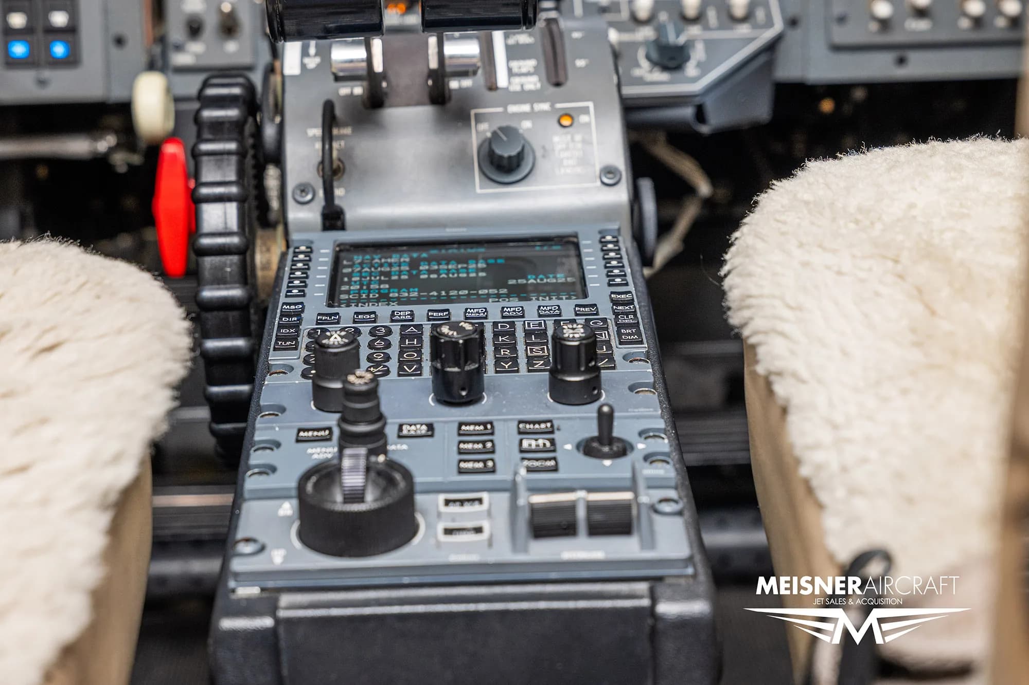 A close-up view of the center console and throttle quadrant in a business jet cockpit.