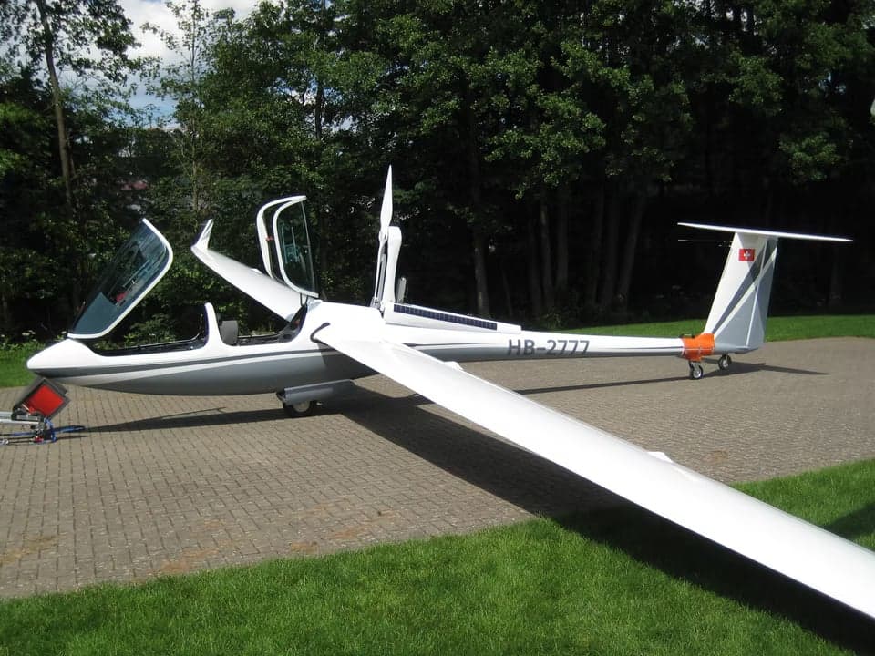 A glider with registration HB-2777 inside a building.