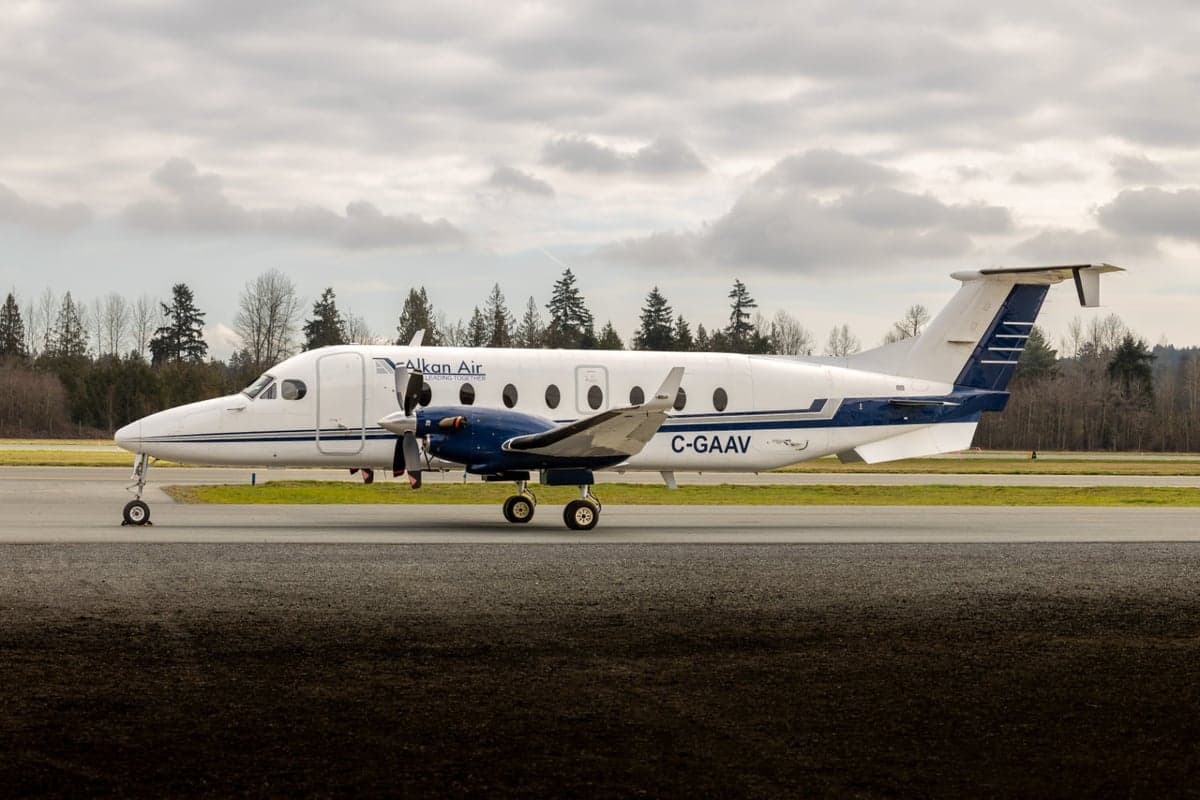 A Beechcraft 1900C in a white and blue paint scheme on the tarmac.