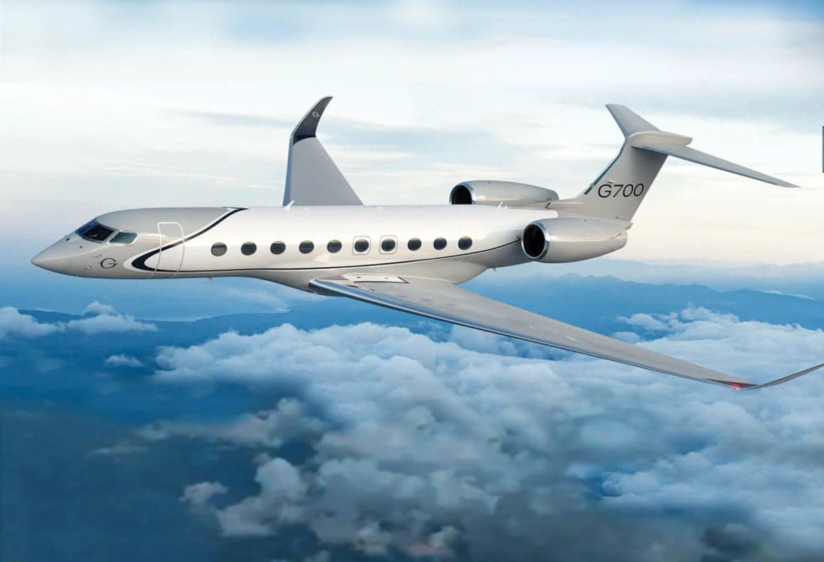A Gulfstream G700 in flight over clouds.