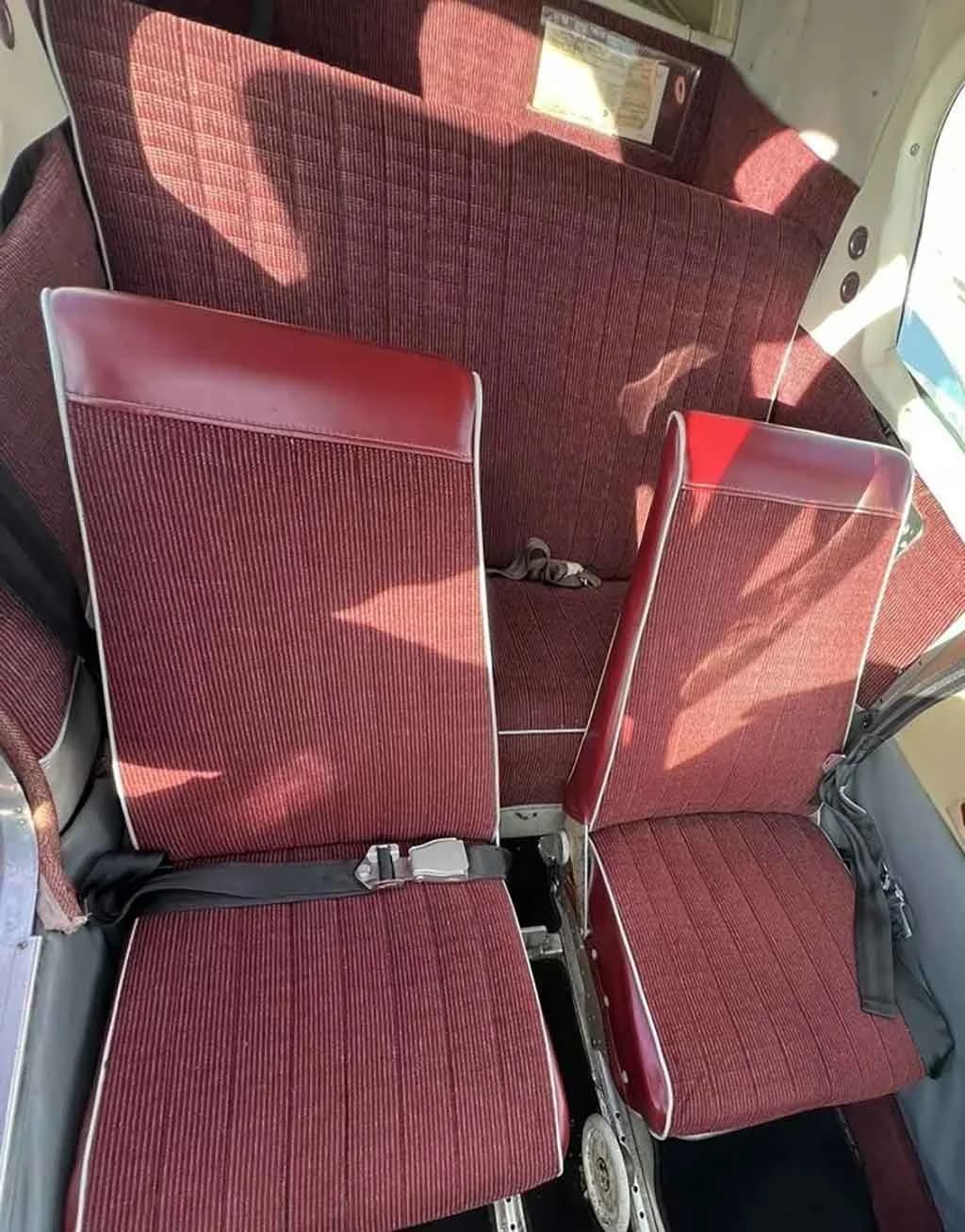 A view of the aircraft's red striped fabric seats, including the front and rear rows.