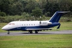 Side view of a Challenger aircraft with a blue and white paint scheme on the tarmac.