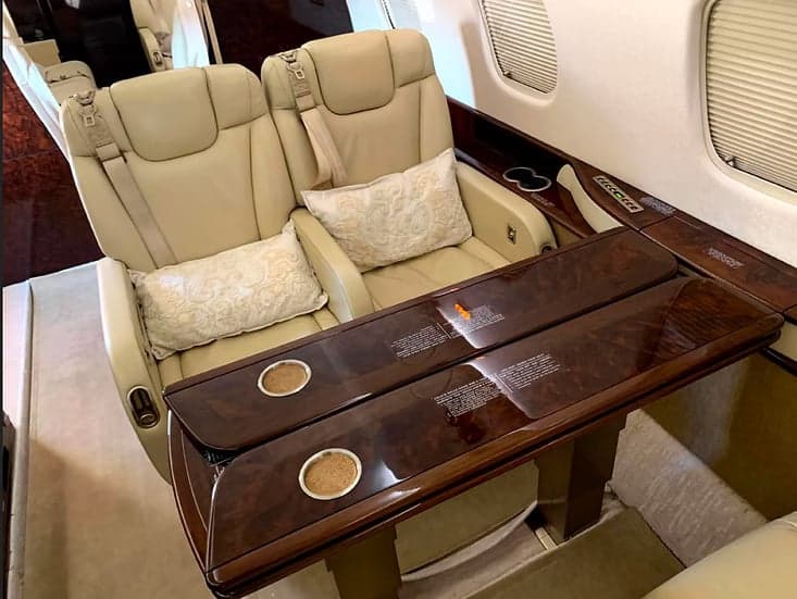 Interior of the aircraft featuring leather seats and a table.