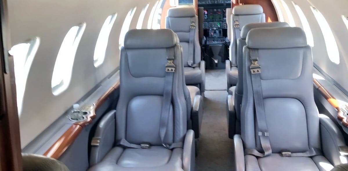Aircraft cabin with gray leather seats.