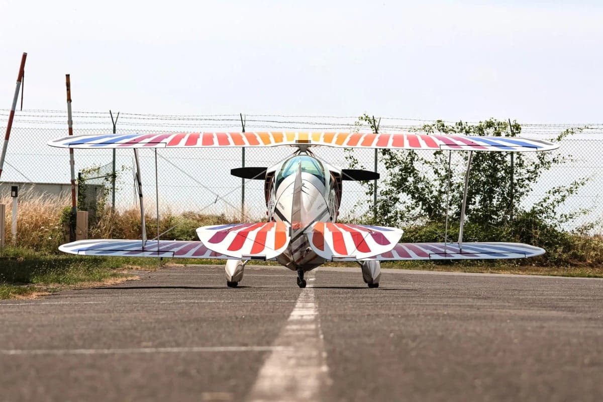 Rear view of the Christen Eagle II biplane with colorful stripes on the wings.