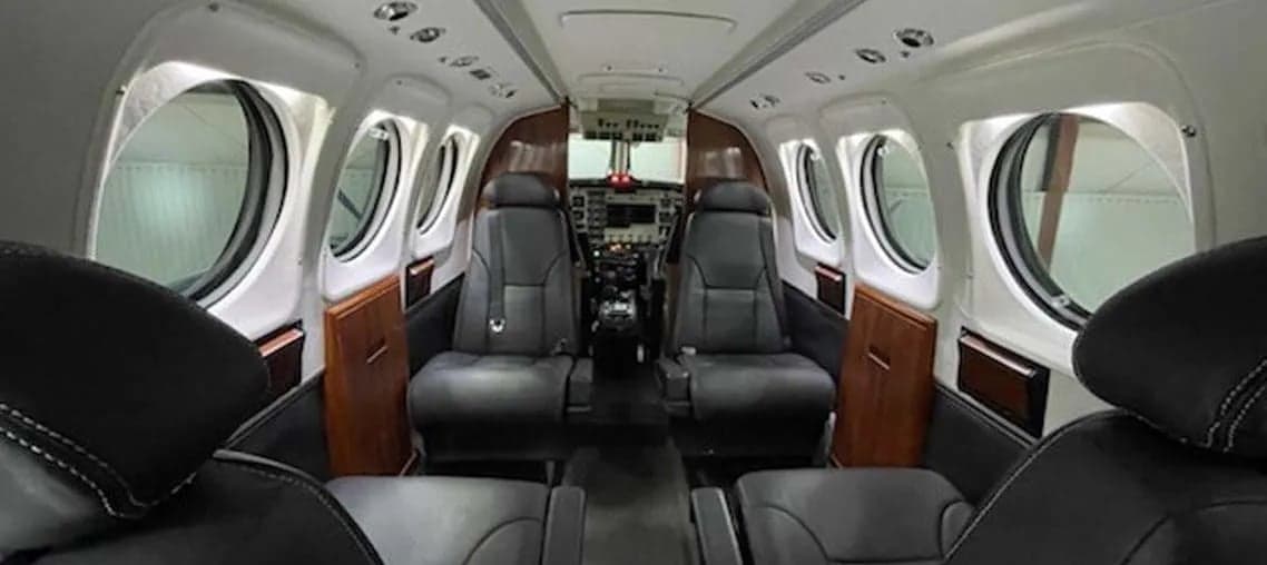 View of the aircraft interior showing the cabin seats and cockpit.